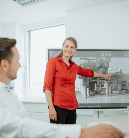 Ingenieurin erl&auml;utert dem Kunden die Funktionsweise der Anlage an einem Monitor