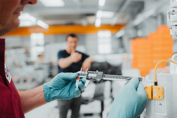 Anlagenpr&uuml;fung: der Servicemitarbeiter h&auml;lt ein Pr&uuml;finstrument f&uuml;r Wartung und Instandsetzung in der Hand